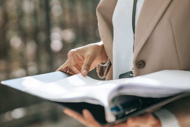 person reading through a binder of documents